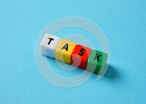 Business tasks and project management concept. The word task on colorful cubes on blue background