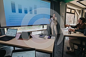 Business team analyzing data during a presentation in a modern classroom setting