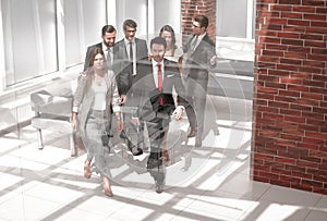 Business team, businesspeople group walking at modern bright office interior