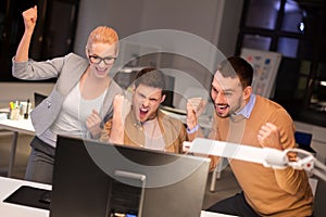Business team celebrating success at night office