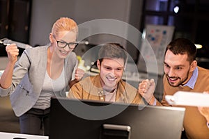 Business team celebrating success at night office