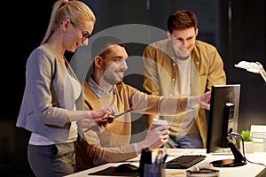 Business team with computer working late at office