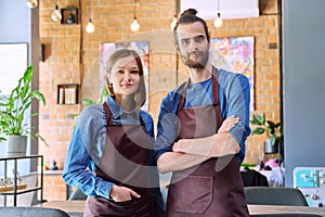 Business team, confident colleagues young man and woman in aprons at workplace
