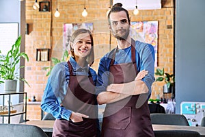 Business team, confident colleagues young man and woman in aprons at workplace