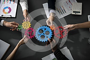 Business team connect pieces of gears. Teamwork, partnership and integration concept photo