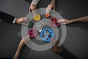 Business team connect pieces of gears to build a new creative idea. Teamwork, partnership and integration concept