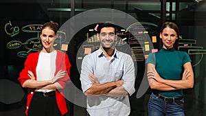 Business team crossing arms while standing together at glass wall. Tracery
