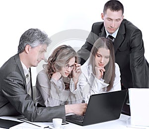 Business team discussing business issues sitting behind a Desk