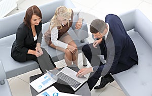 Business team discussing financial documents sitting in the lobby of the office