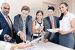 Business team discussing graphs and numbers in meeting