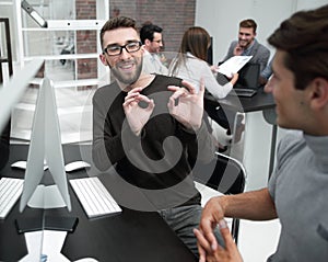 Business team is discussing something sitting at the Desk