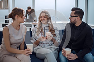 business team is discussing something sitting in the office lobby