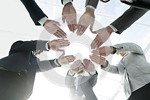 Business team with folded their hands in a circle