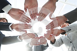 Business team with folded their hands in a circle