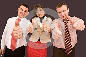 Business team in formal suits with thumbs up