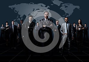 Business team formed of young businessmen standing over a dark background.