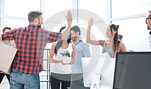 Business team is giving each other a high five in the new office