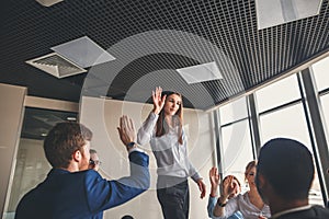 Business team giving a high fives gesture as they laugh and cheer their success