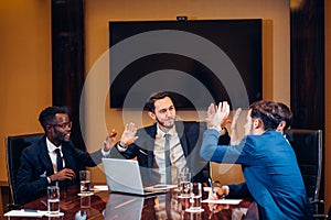 Business team giving high fives gesture as they laugh and cheer their success