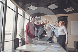 Business team giving a high fives gesture as they laugh and cheer their success