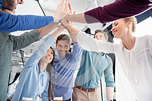 Business team giving highfive together on workplace in office