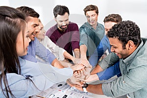 Business team giving highfive together on workplace in office