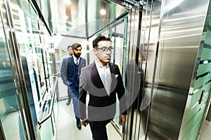 Business team group going on elevator. Business people in a large glass elevator in a modern office. Corporate