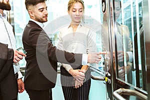 Business team group going on elevator. Business people in a large glass elevator in a modern office. Corporate