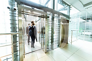 Business team group going on elevator. Business people in a large glass elevator in a modern office. Corporate