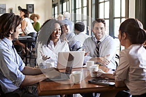 Business Team Having Informal Meeting Around Table In Coffee Shop