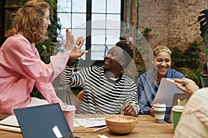 Business Team High Five at Meeting Table