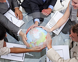 Business team holding a terrestrial globe