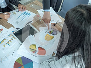 Business team image of male pen pointing at business document during discussion at meeting and using pen with financial diagram