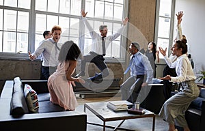 Business team jump for joy at hitting target in meeting