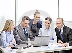 Business team with laptop having discussion