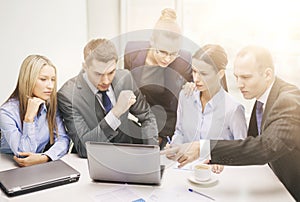 Business team with laptop having discussion