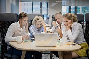 Business team looking at computer with shocked expressions