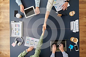 Business team makes handshake at office table