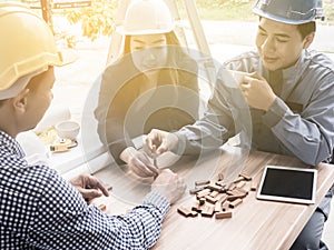 Business team making a structure with wooden cubes. Building a business concept.,Team of Asian engineers discussing blueprint at