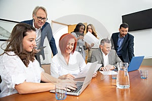 Business team of men and women in an office analyzing the evolution of the company