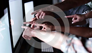 Business team is pointing to the monitors of their computers