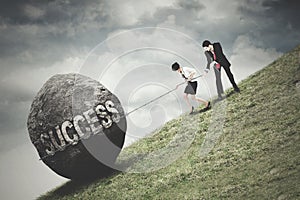 Business team pull a boulder with Success text