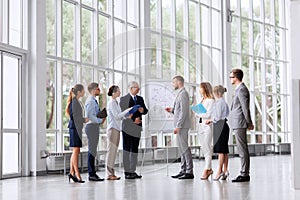 Business team with scheme on flip chart at office