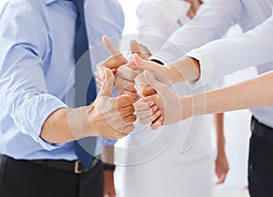 Business team showing thumbs up in office