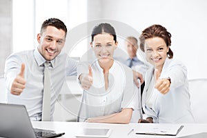 Business team showing thumbs up in office