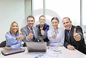 Business team showing thumbs up in office