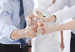 Business team showing thumbs up in office