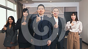 Business team showing thumbs up sign gesture and looking at camera