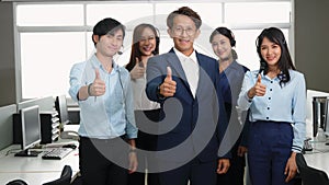 Business team showing thumbs up sign gesture and looking at camera