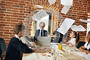 Business team sitting at the table while documents are flying above the desk
